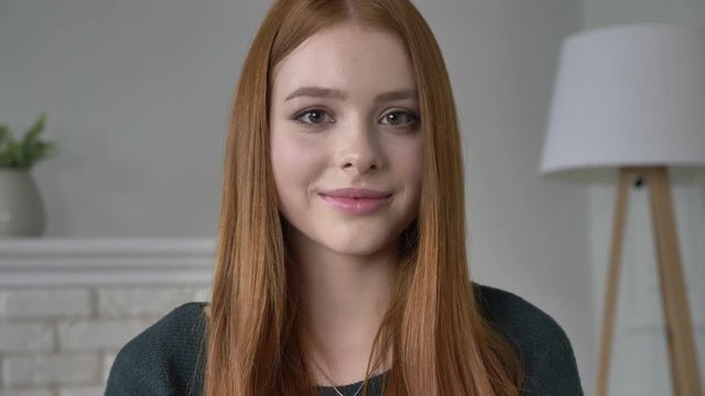 Young red-haired girl blogger, portrait, looking at camera, serious face, smiling, beautiful eyes, look 60 fps