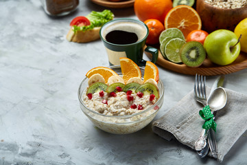 Breakfast still life with oatmeal porridge, fruits and coffee cup, top view, selective focus, shallow depth of field.