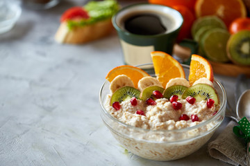 Breakfast still life with oatmeal porridge, fruits and coffee cup, top view, selective focus, shallow depth of field.