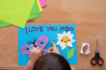 Children's hands are making greeting card for mother on the occasion of the Mother's day.