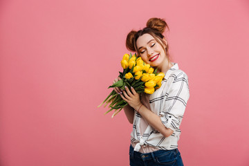 Portrait of a lovely young girl holding yellow tulips