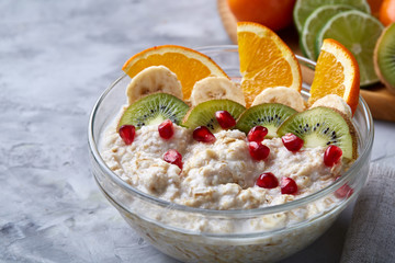 Breakfast still life with oatmeal porridge and fruits, top view, selective focus, shallow depth of field.