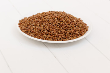 plate of buckwheat isolated on white background. Top view.