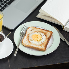 Business breakfast. Egg fried in toast with coffee and orange juice