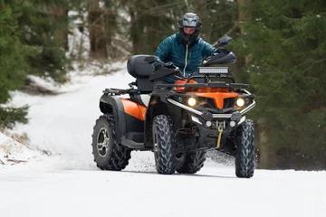 Rolgordijnen Man rijdt op een quad in de winter © yakub88