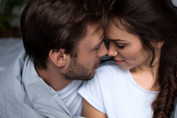 Young attractive couple hugging in bedroom