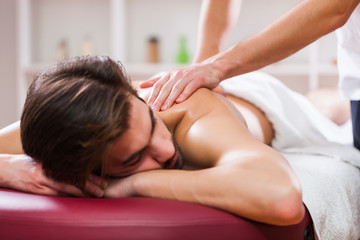 Obraz na płótnie Canvas Young man is enjoying massage on spa treatment. 