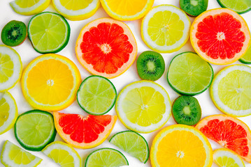 Slices of lemon, lime, orange, kiwi and grapefruit on a white background. Flatt Layout. Summer Pattern