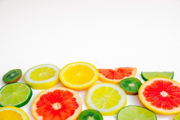Summer fruit background with lime, lemon, orange, kiwi and grapefruit with space for text on a white background