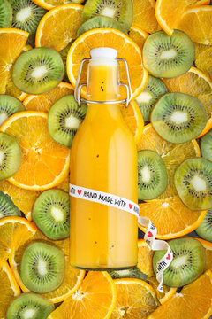 Bottle of juice on kiwifruit and orange pattern