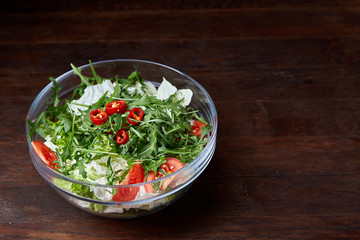 Dietary mixed salad in glass sultana on vintage wooden background, selective focus