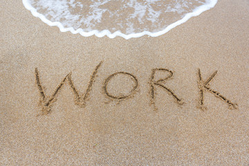 The word inscription work on the sand on the beach.