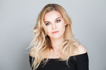 Naklejka premium Blonde Beauty. Beautiful Young Woman with Blonde Curly Hair Portrait