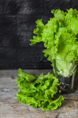 green lettuce leaves (bunch of lettuce) on a wooden surface