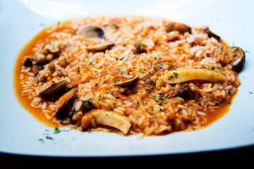 Tasty risotto with Shrimp, fresh herbs vegetables on a white plate
