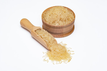 Rice in a wooden bowl and in a wooden scoop on a white background.