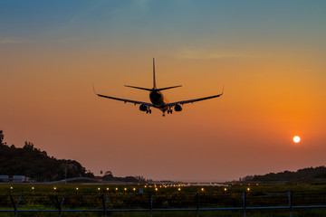 Airplane just arrive to the airport ready to landing on the runway at sunset,  transportation worldwide for passengers transmission