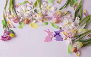 on a pink background tulips, carnations, greens, eggs, easter bunny and feathers - easter background