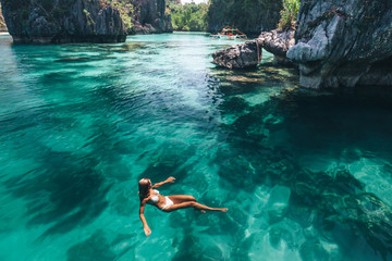 Woman swimming in clear sea water in Asia