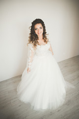 Luxury bride in white dress posing while preparing for the wedding ceremony