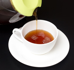 Tea in a cup on a black background