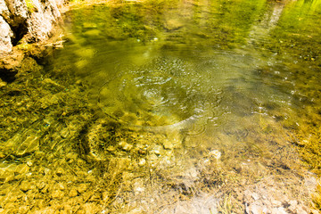 Circles on the surface of water with stones on the bottom