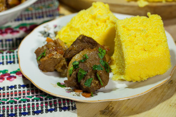 Tasty polenta with meat. Traditional Romanian dish made from beef and pork served with polenta. Polenta and stew