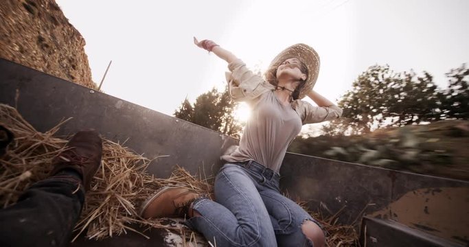 Woman with friend in the back of a pick-up truck