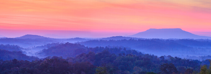 Panoramic landscape of blue mountains at sunrise.