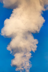 smoke from a pipe in the factory against a blue sky