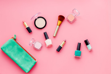 Obraz na płótnie Canvas Beauty set with decorative cosmetics. nail polish, brushes and bag on pink background top view mockup