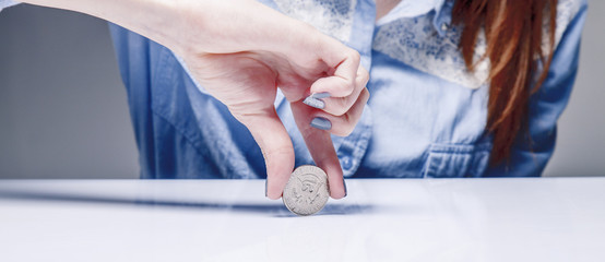 Woman spinning a coin to make decision. Heads or tails game. (chance, opportunity, fortune, luck...