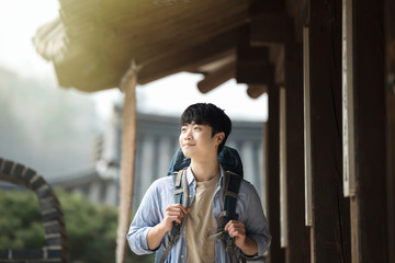 A young man doing a backpacking trip in a Korean traditional house.