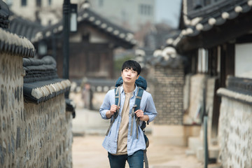 A young man doing a backpacking trip in a Korean traditional house.