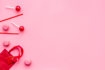Gift concept. Sweets, paper bag for gift on pink background top view mock up