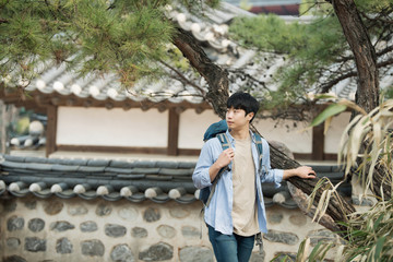 A young man doing a backpacking trip in a Korean traditional house.