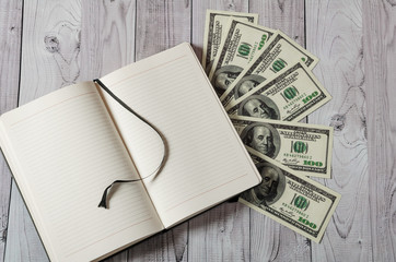 Notepad, pen and money on a light wooden background