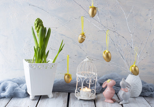 Easter background: hyacinth, painted golden eggs and two Easter bunnies