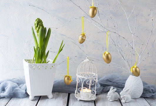 Easter background: hyacinth, painted golden eggs and two Easter bunnies