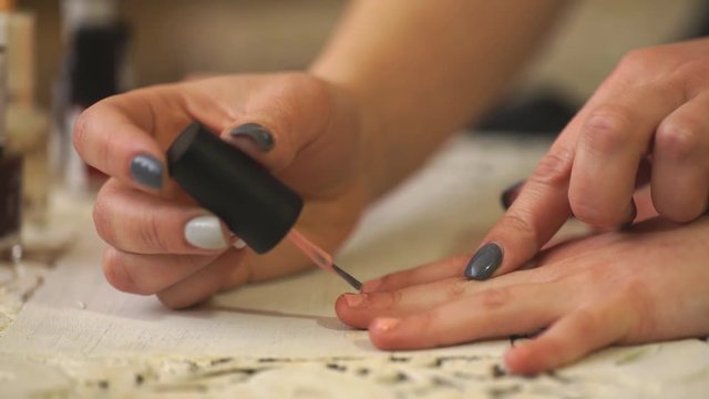 Mother and daughter painting their finger nails with polish