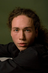 Fototapeta premium Attractive and stylish guy with curly hair and a sports figure