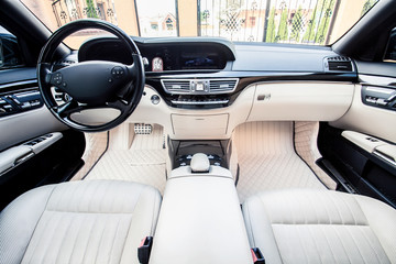 Luxury car interior. Steering wheel, shift lever and dashboard.