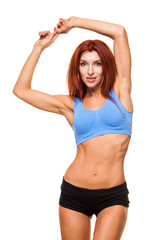 Muscular young woman athlete standing on white background. Woman bodybuilder relaxing after exercise.