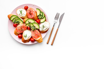 Healthy lunch with mini sandwiches cheese, fish and avocado on white background top view space for text