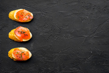 homemade sandwiches with french baguette, salmon on black background top view mock-up