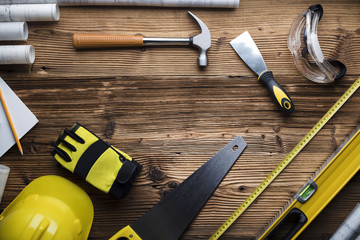 Construction and renovation concept. Contractor tools, on wooden table. Top view shot.