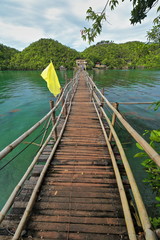 Obraz premium Bamboo and wooden planks footbridge with flags-Latasan island. Sipalay-Philippines. 0359