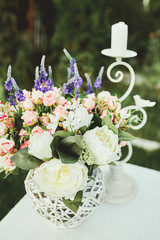 Wedding decor, flowers, rings, bouquet in the hands, rings, groom and bride