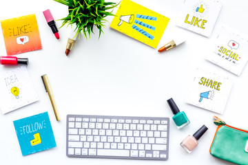 Beauty blogger workplace concept. Keyboard, cosmetics, social media icons on white desk top view space for text