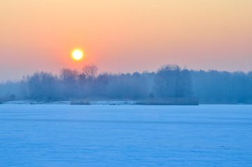 Beautiful winter sunrise. A frosty morning by the lake.